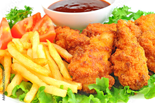 Chicken wings and drumsticks with french fries, barbecue sauce and vegetables