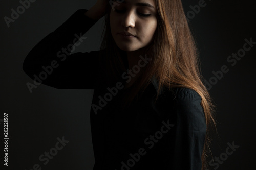Bild auf Leinwand The young woman in the studio in a low key