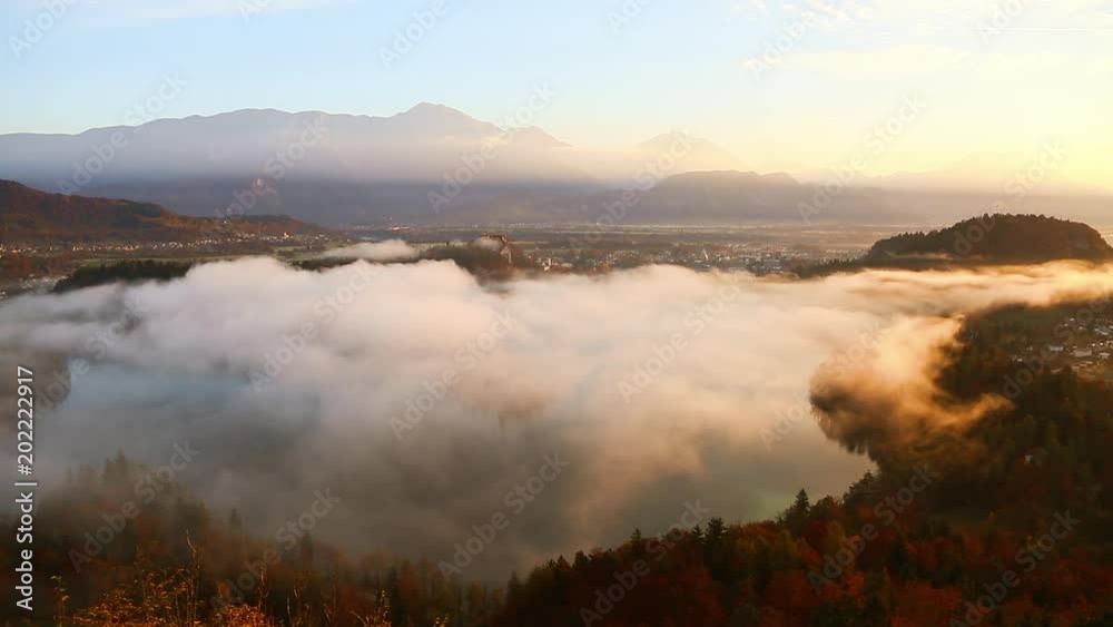 Aerial view of the foggy alpine lake Bled, Osojnica viewpoint. Location Julian Alps, Slovenia, Europe. Aerial view of the foggy alpine lake Bled, Osojnica viewpoint. Location Julian Alps, Slovenia, Europe.