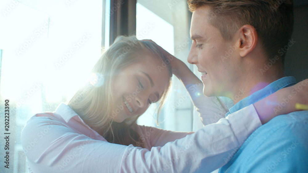 Fototapeta premium Portrait of happy couple standing together near the window.