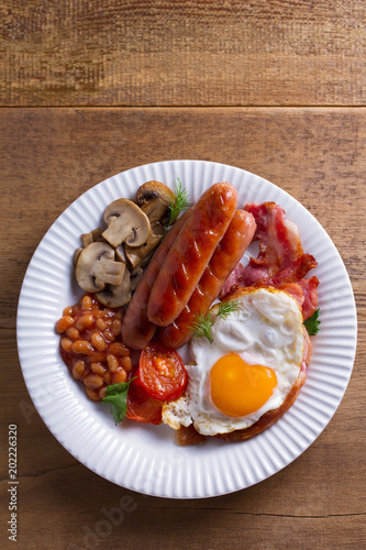 Full English or Irish breakfast: sausages, bacon, egg, mushrooms, tomatoes and beans. Nutritious morning meal