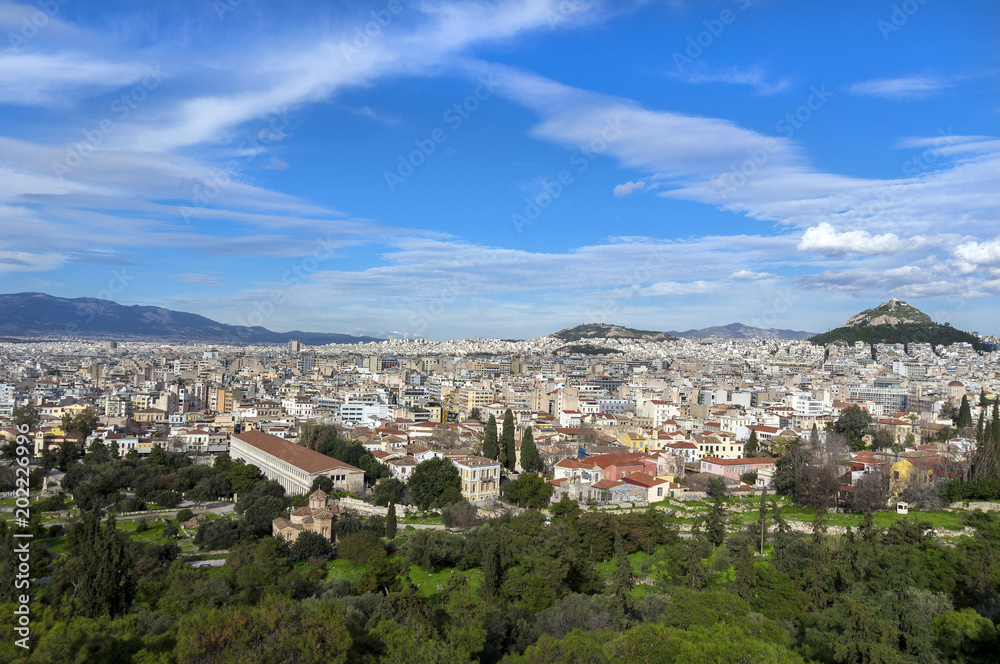 Athens, Attica - Greece. Panoramic view of the city of Athens as seen from the vantage point of Areopagus hill in Plaka, Acropolis. Lucabettus hill in the background. Sunny day with blue cloudy sky