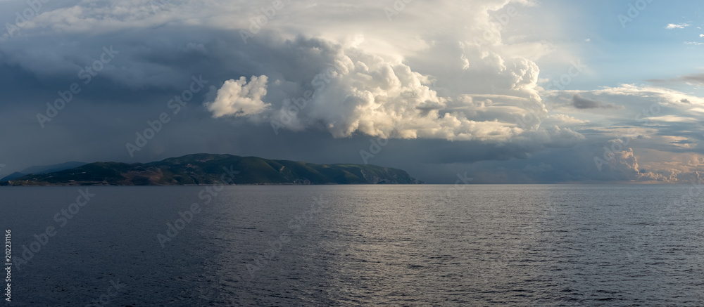 Obraz premium Sea landscape with stormy cloudy sky and Zakynthos island in background. Ionian Sea