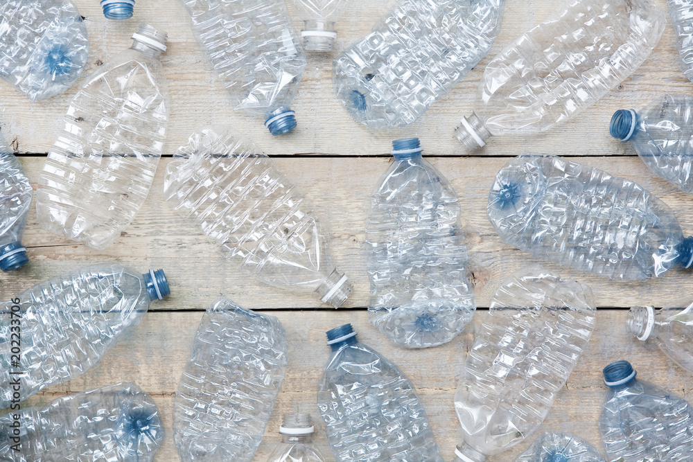 Close up of used plastic water bottles, ready for recycling in a flat lay pattern on a wooden table. Horizontal. Close up of used plastic water bottles, ready for recycling in a flat lay pattern on a wooden table. Horizontal.