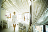 Beautiful blonde bride posing in white interior