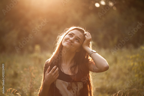 Young woman standing outdoors at sunset