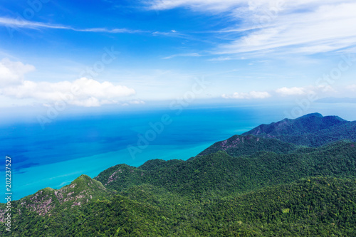 Mountain covered jungle on tropical island in sea