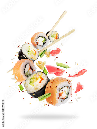 Different fresh sushi rolls with chopsticks frozen in the air on white background photo