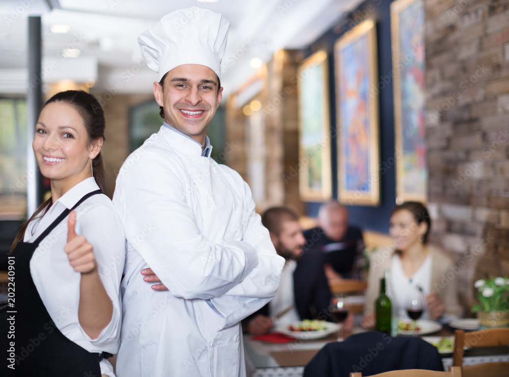 Smiling waitress with chef in the restaurant