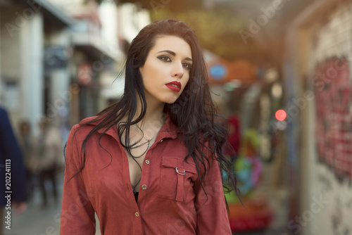 beauty brunette girl with red dress in the middle of the city