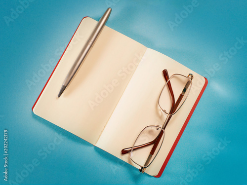 Open note, pen and eyeglass...