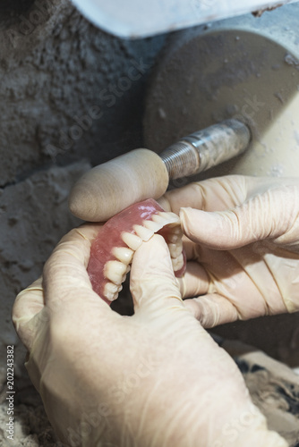 Dental technician working on dental prosthetic for to polish up