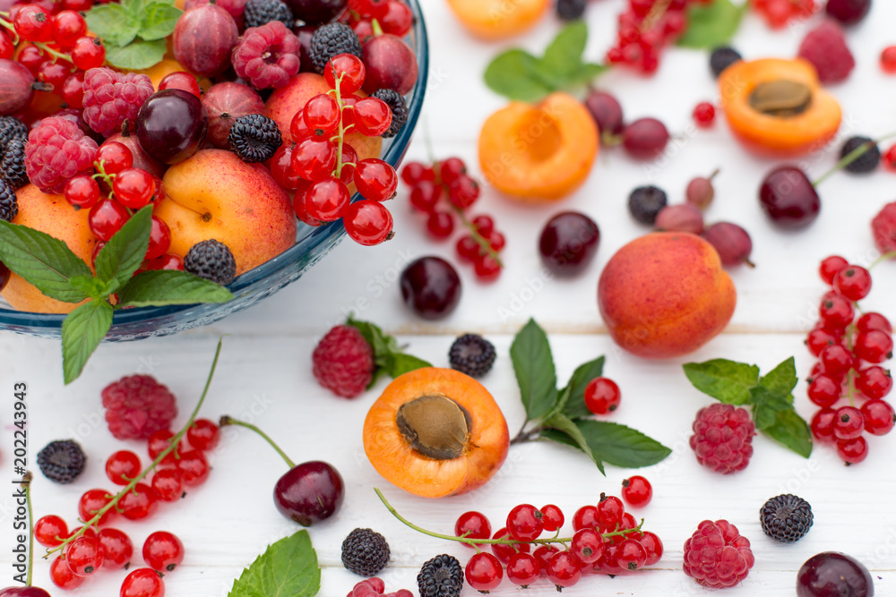 Fresh and sweet summer berries in plate on white background. Raspberry, blackberry, redcurrant, currant, gooseberry, apricot, cherry and mint. Top view. Fresh and sweet summer berries in plate on white background. Raspberry, blackberry, redcurrant, currant, gooseberry, apricot, cherry and mint. Top view.