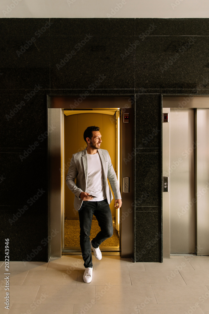 young businessman leaving the elevator in a finance building. business concept