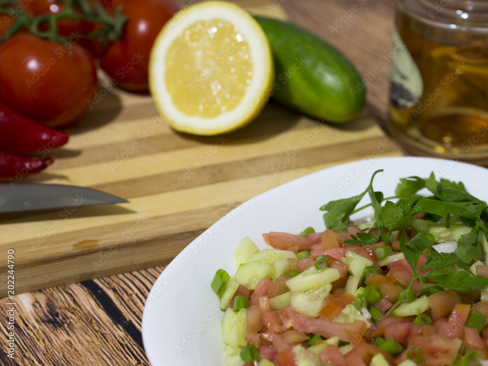 salad on wooden table and freshly washed vegetables