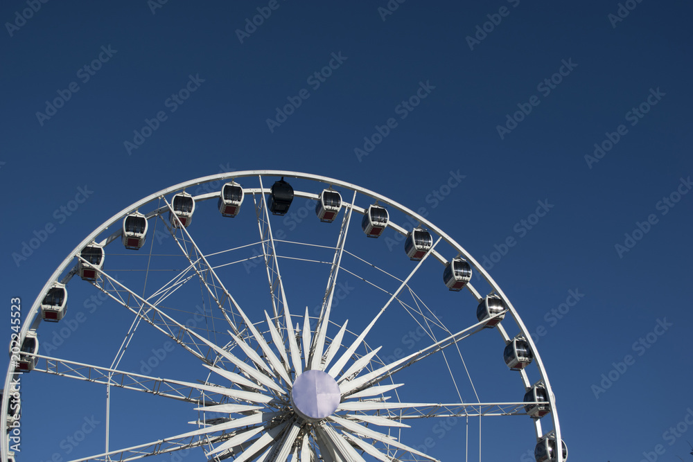 Nice perspective of a Giant Festival Ferris Wheel under blue sky
