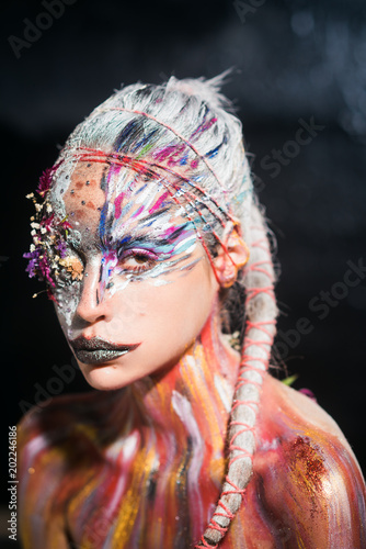 Woman with colorful neon paint makeup. Indian woman with creative body art. Holi girl with colored trendy hair. Beauty model with fashion look. Paint party, colors festival and indian culture