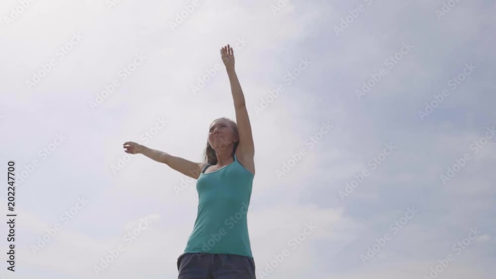 Happy beautiful blonde woman having fun on the beach with her hands up. Young girl embracing the world. Victory, success and happiness concept. Happy beautiful blonde woman having fun on the beach with her hands up. Young girl embracing the world. Victory, success and happiness concept.