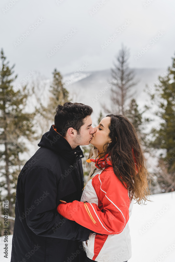 Fototapeta premium Couple kiss in snowy landscape