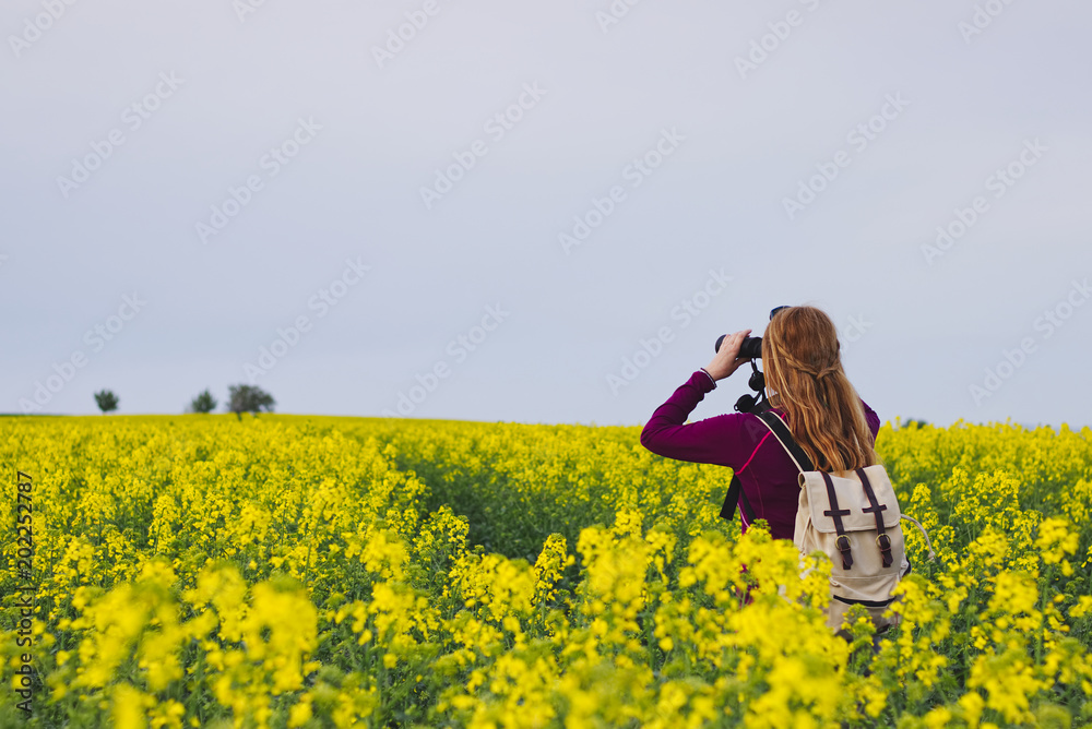 Hiking woman watching landscape with binoculars Hiking woman watching landscape with binoculars