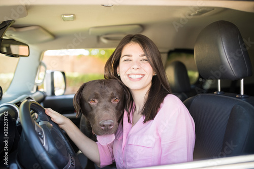 Cheerful woman in car with dog