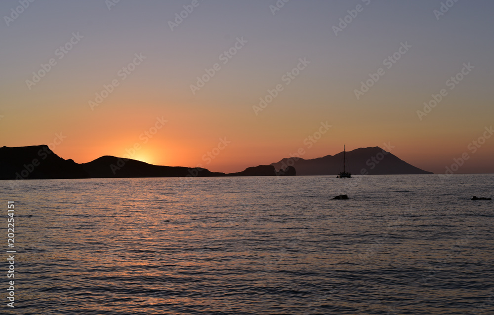 Sailing boat at sunset off Milos, Cyclades Island, Greece