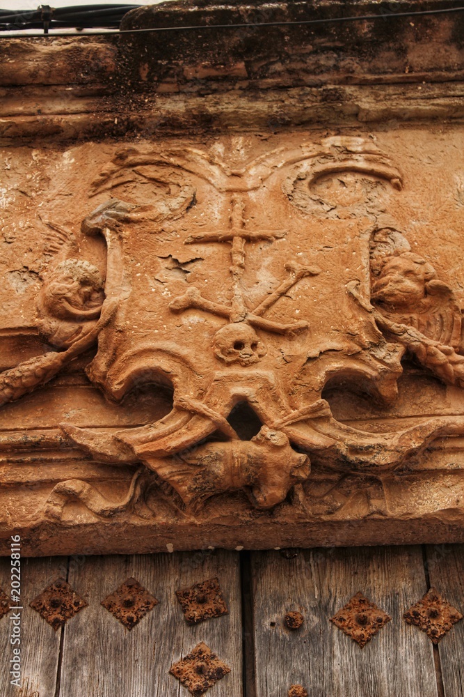 Old wooden door and coat of arms of the Holy Inquisition