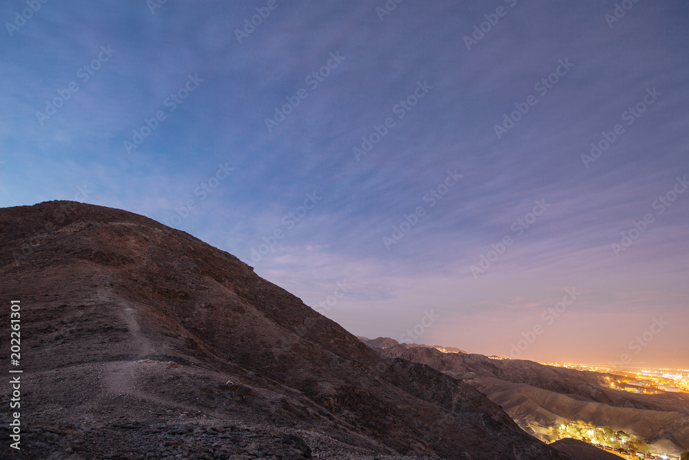 Waypath in the mountains near of Eilat city in the desert  in the Israil in the evening  with blue sky and city lights