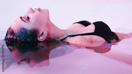 Young woman floating in Spa bath or swimming pool, she is very relaxed. Welness concept photo
