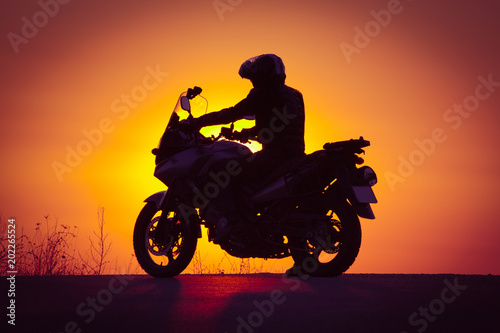silhouette of rider on a motorbike admiring sunset - space for your text © Melinda Nagy