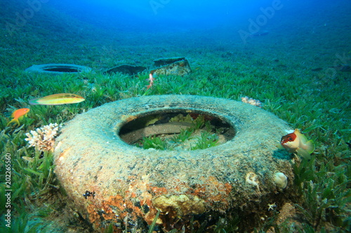 Rubber car tyres pollution on ocean coral reef. Plastic pollutes sea 