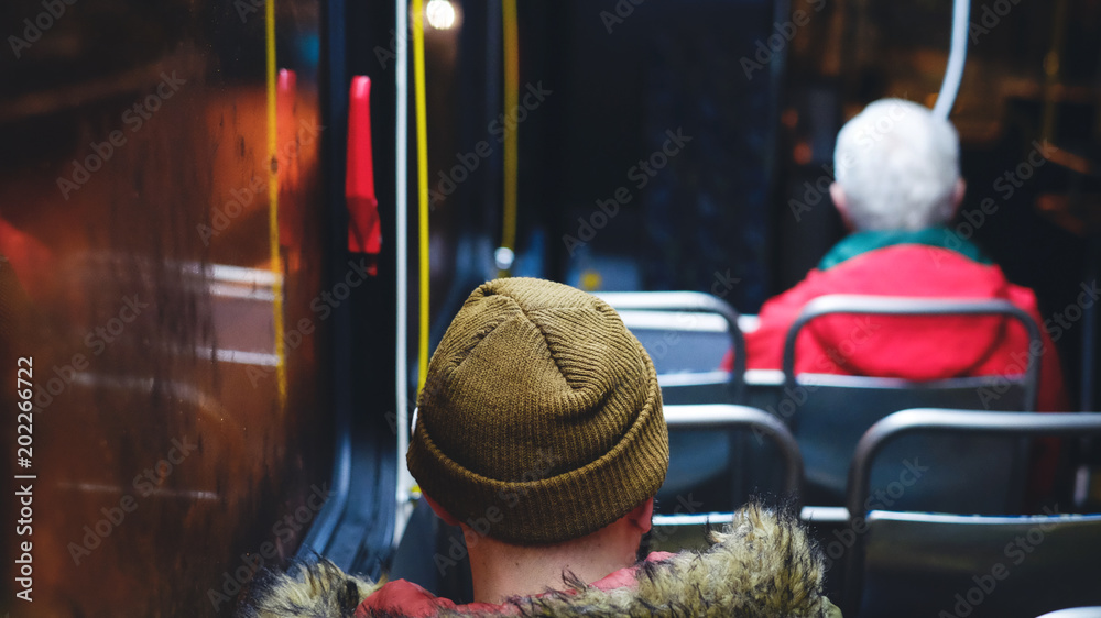 Back view of lone bus rider wearing bonnet at rainy night Stock Photo ...