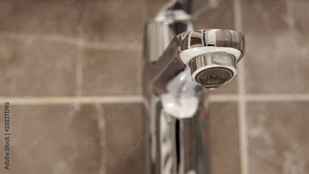 Metal tap and water drop dripping loop background close up cinematic dof Metal tap and water drop dripping loop background close up cinematic dof