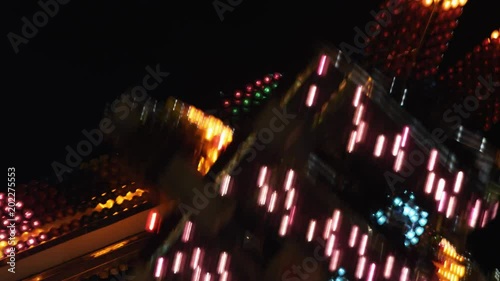 Brightly lighted carnival ride turning close to camera photo