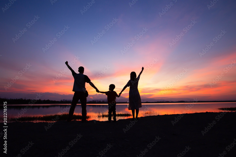 Fototapeta premium The shadow of the family, parents, children, lakeside evening.