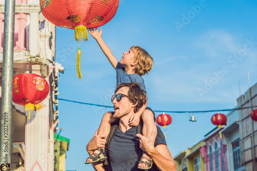 Dad and son are tourists on the Street in the Portugese style Romani in Phuket Town. Also called Chinatown or the old town photo