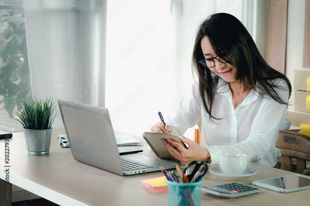 Asian beautiful young business woman owner of the SME start up company are get purchase orders from customers in the online trading business with a computer laptop in the Home Office Asian beautiful young business woman owner of the SME start up company are get purchase orders from customers in the online trading business with a computer laptop in the Home Office
