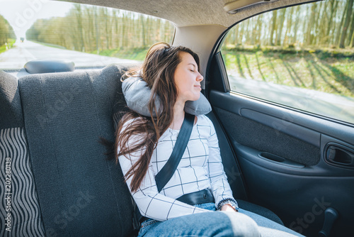 young woman sleeping in car on backseats. travel concept