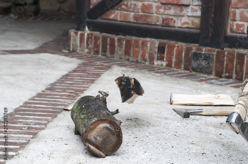 A man splitting a log on a wood chopping block photo