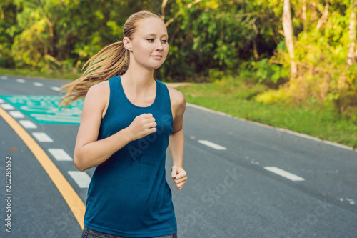 Sporty woman running on road at sunrise. Fitness and workout wellness concept photo