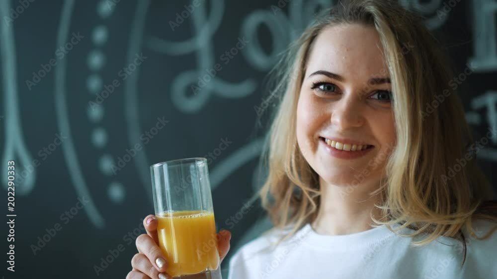 Young beautiful woman drinking juice, girl drink orange fresh on morning breakfast Young beautiful woman drinking juice, girl drink orange fresh on morning breakfast