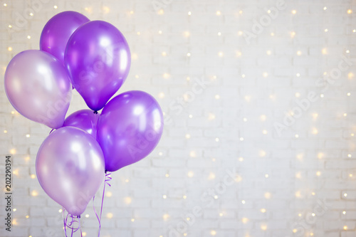 party concept - air balloons over white brick wall background with lights