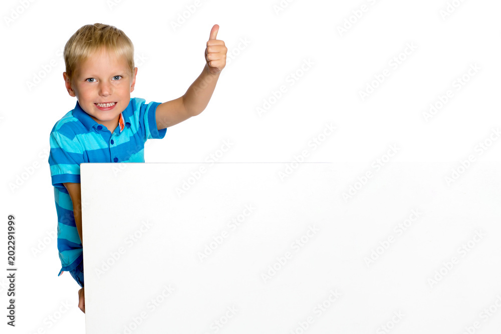 A little boy is looking from behind an empty banner. A little boy is looking from behind an empty banner.