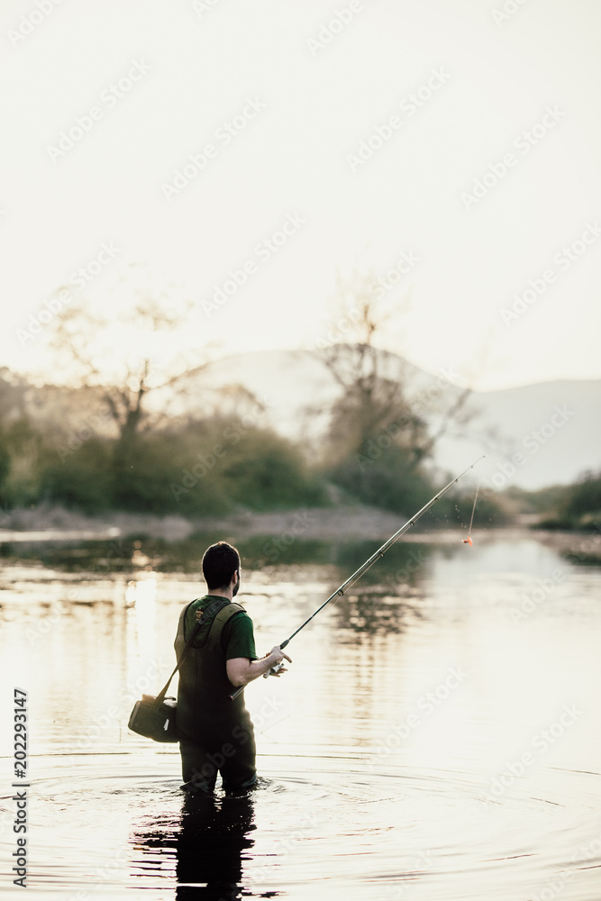 Fisherman in the lake at sunset