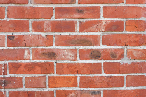 Red brickwork with different defects, shabby texture