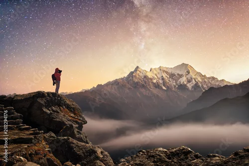Obraz Fotograf podróżnik, który robi zdjęcie gwiaździstego nieba i wschodu słońca w górach