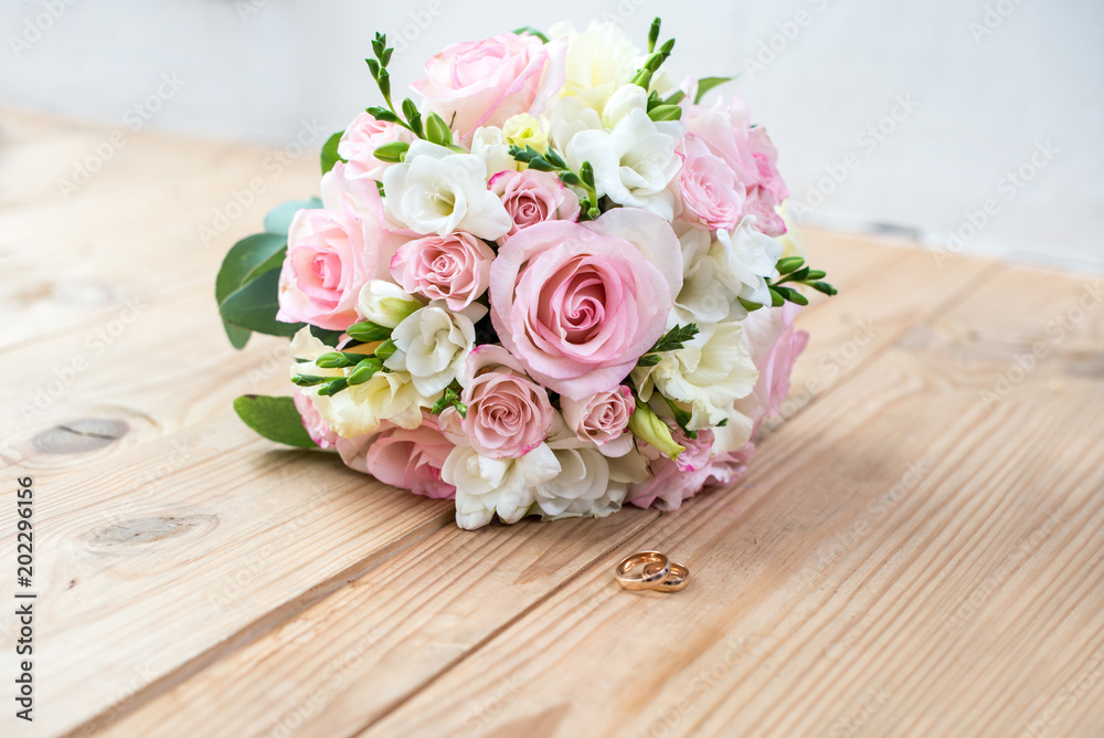 Details of the morning of the wedding day. two gold wedding rings are on the brown wood table Details of the morning of the wedding day. two gold wedding rings are on the brown wood table