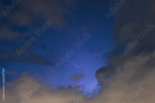 Stroke of lightning with storm clouds