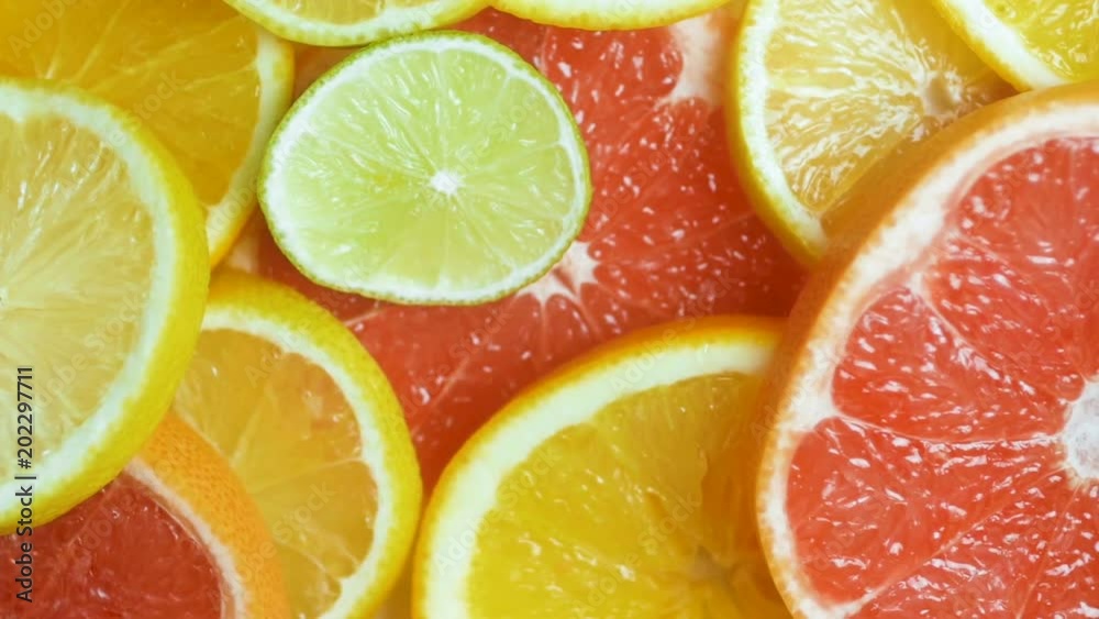 Slow motion footage of camera panning over fresh slices of citrus fruits