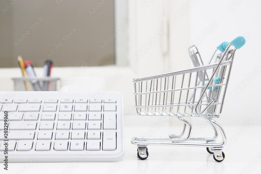 shopping online, desktop with shopping cart and computer keyboard shopping online, desktop with shopping cart and computer keyboard